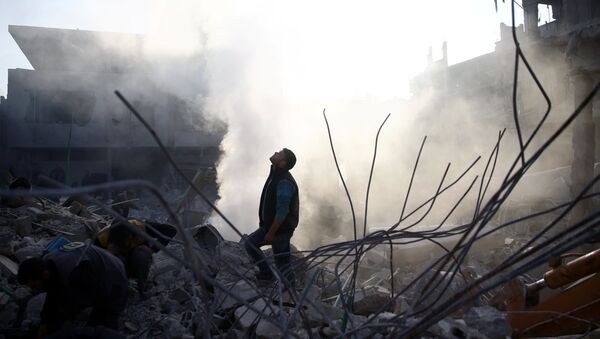 A man stands on rubble of damaged buildings after an airstrike in the besieged town of Hamoria, Eastern Ghouta, in Damascus, Syria - Sputnik Afrique