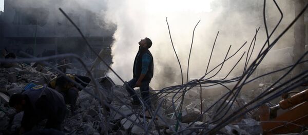 A man stands on rubble of damaged buildings after an airstrike in the besieged town of Hamoria, Eastern Ghouta, in Damascus, Syria - Sputnik Afrique