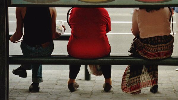 Three Chinese commuters wait for their ride at a bus stop here in Beijing amid an advertising board Monday May 19, 1997. - Sputnik Afrique