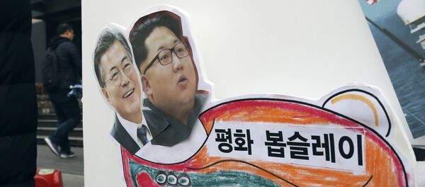 In this Tuesday, Jan. 16, 2018, photo, pictures of South Korean President Moon Jae-in, left, and North Korean leader Kim Jong Un are seen on a sign during a rally for a peaceful Winter Olympics in Seoul, South Korea. - Sputnik Afrique