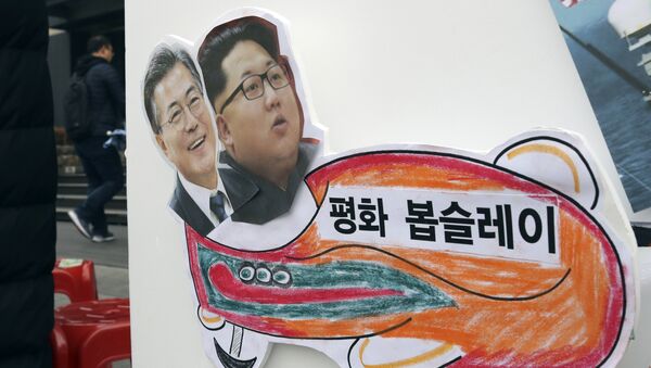 In this Tuesday, Jan. 16, 2018, photo, pictures of South Korean President Moon Jae-in, left, and North Korean leader Kim Jong Un are seen on a sign during a rally for a peaceful Winter Olympics in Seoul, South Korea. - Sputnik Afrique