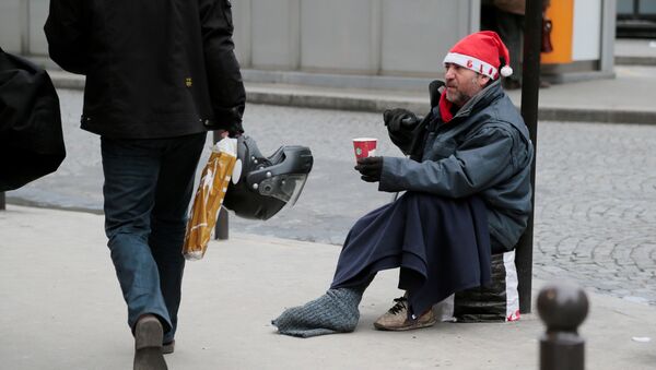 A homeless person wearing a Santa Claus hat begs for money on December 21, 2012 in Paris, a few days before Christmas. - Sputnik Afrique