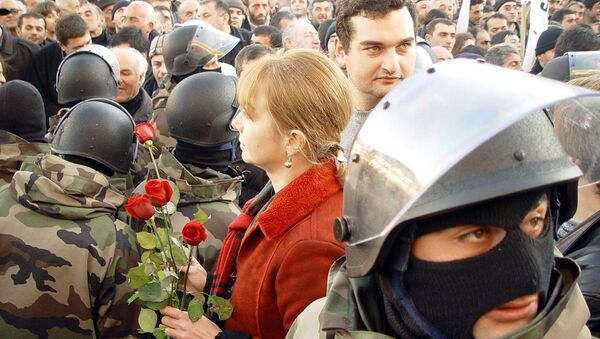 A woman gives flowers to members of the National Guard in Tbilisi, 23 November 2003. Georgia was plunged into chaos, when President Eduard Shevardnadze declared a state of emergency 22 November after angry demonstrators swarmed into parliament and an opposition leader laid claim to the presidency. - Sputnik Afrique