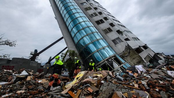 Спасатели выходят из здания Yun Tsui, которое поддерживается подпорками после землетрясения городе Хуалянь, Тайвань - Sputnik Afrique