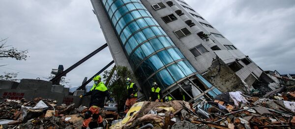 Спасатели выходят из здания Yun Tsui, которое поддерживается подпорками после землетрясения городе Хуалянь, Тайвань - Sputnik Afrique