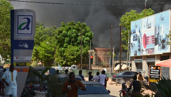 People watch as black smoke rises as the capital of Burkina Faso came under multiple attacks on March 2, 2018, targeting the French embassy, the French cultural centre and the country's military headquarters - Sputnik Afrique