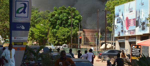 People watch as black smoke rises as the capital of Burkina Faso came under multiple attacks on March 2, 2018, targeting the French embassy, the French cultural centre and the country's military headquarters - Sputnik Afrique