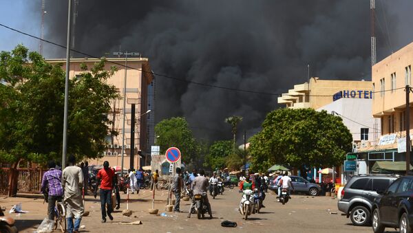 People watch as black smoke rises as the capital of Burkina Faso came under multiple attacks on March 2, 2018, targeting the French embassy, the French cultural centre and the country's military headquarters - Sputnik Afrique