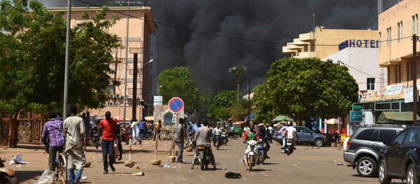People watch as black smoke rises as the capital of Burkina Faso came under multiple attacks on March 2, 2018, targeting the French embassy, the French cultural centre and the country's military headquarters - Sputnik Afrique