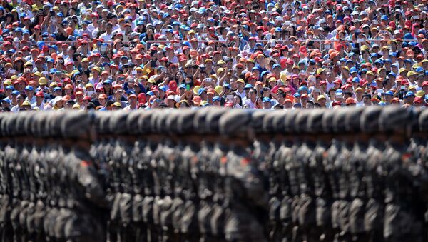 Зрители наблюдают за маршем китайских солдат во  время военного парада на площади Тяньаньмэнь в Пекине - Sputnik Afrique