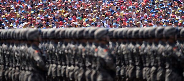 Зрители наблюдают за маршем китайских солдат во  время военного парада на площади Тяньаньмэнь в Пекине - Sputnik Afrique