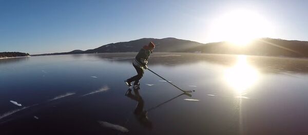 Des hockeyeurs patinent sur la glace cristalline d'un lac - Sputnik Afrique