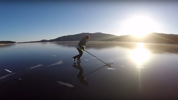 Des hockeyeurs patinent sur la glace cristalline d'un lac - Sputnik Afrique