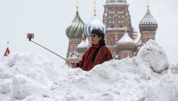 A woman is photographed near the St Basil Cathedral on the Red Square - Sputnik Afrique