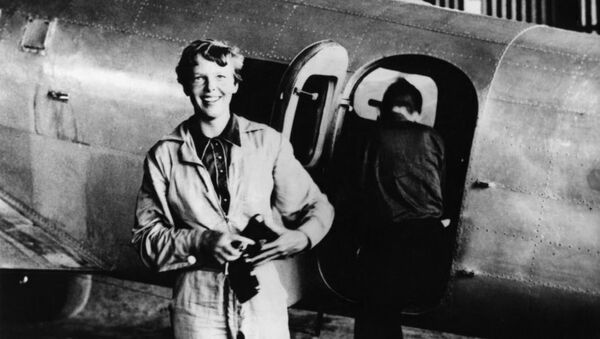 Amelia Earhart standing by her Lockheed Electra with Fred Noonan in the background - Sputnik Afrique
