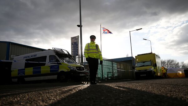 A police officer stands guard at a car recovery depot in Norton Enterprise Park, where Sergei Skripal's car was originally transported, in Salisbury, Britain, March 13, 2018 - Sputnik Afrique