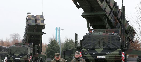 Soldiers of the Air Defence Missile Squadron 2 walk past Patriot missile launchers in the background in Bad Suelze, northern Germany on December 4, 2012 - Sputnik Afrique