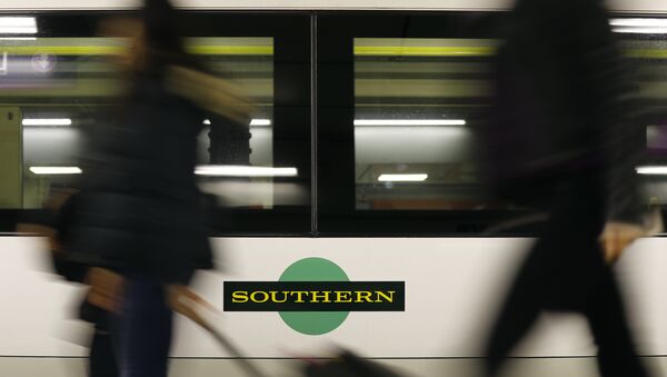 Travelers pass a train as Southern railway workers are on strike at Victoria Station in London - Sputnik Afrique