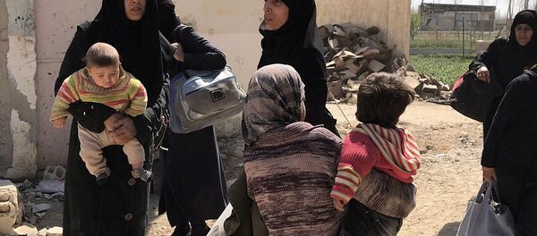 Мирные жители выходят из Восточной Гуты через гуманитарный коридор в поселении Хаммурия - Sputnik Afrique