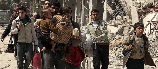 Мирные жители выходят из Восточной Гуты через гуманитарный коридор в поселении Хаммурия - Sputnik Afrique