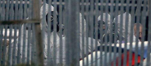 Police officers wear protective suits inside the fence of Ashley Wood Recovery, a vehicle recovery business in Salisbury, England, Tuesday, March 13, 2018. - Sputnik Afrique