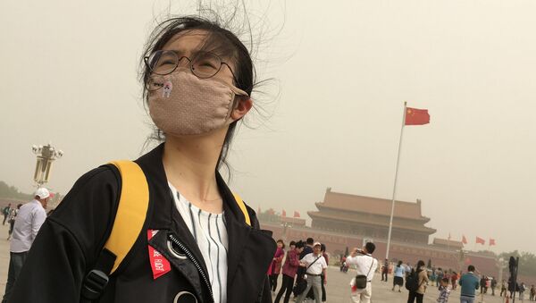 Une jeune fille porte un masque contrela pollution à Pékin - Sputnik Afrique
