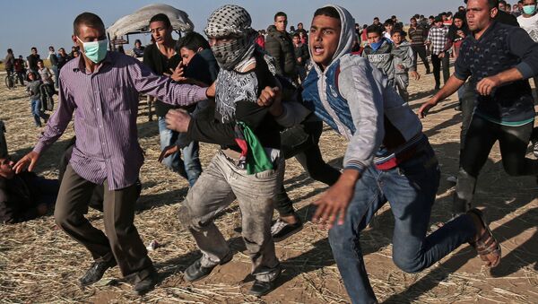 Protesters run during clashes with Israeli security forces following a demonstration near the border with Israel, east of Khan Yunis, in the southern Gaza Strip - Sputnik Afrique