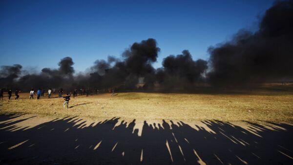 Des manifestants palestiniens pendant les affrontements avec les militaires israéliens sur la frontière entre Israël et la bande de Gaza - Sputnik Afrique