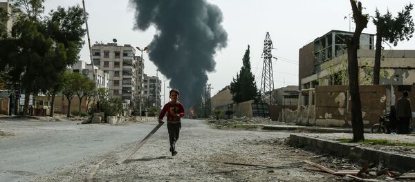 A child runs along a street in front of clouds of smoke billowing following a reported air strike on Douma, the main town of Syria's rebel enclave of Eastern Ghouta - Sputnik Afrique