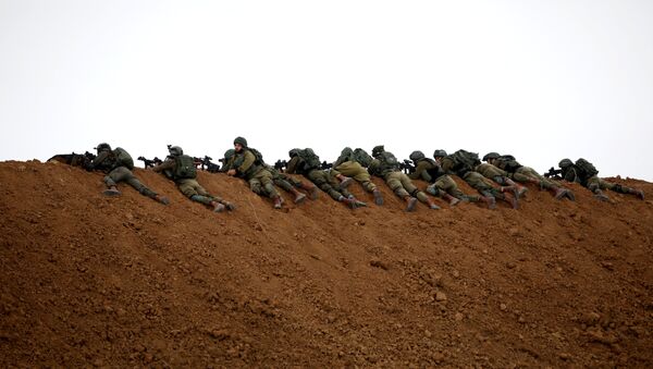 Israeli soldiers are seen next to the border fence on the Israeli side of the border with the northern Gaza Strip, Israel - Sputnik Afrique
