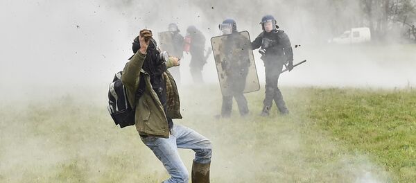 A protester hurls stone toward riot forces on April 10, 2018 on the second day of a police operation to raze the decade-old camp known as ZAD (Zone a Defendre - Zone to defend) at Notre-Dame-des-Landes, near the western city of Nantes, and evict the last of the protesters who had refused to leave despite the government agreeing to ditch a proposed airport. - Sputnik Afrique