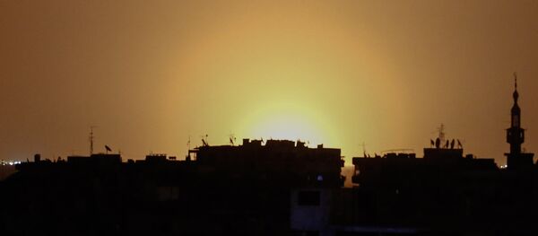 A photo taken from the rebel-held town of Douma shows flames rising in the distance which are believed to be coming from Damascus International Airport following an explosion early in the morning of April 27, 2017 - Sputnik Afrique