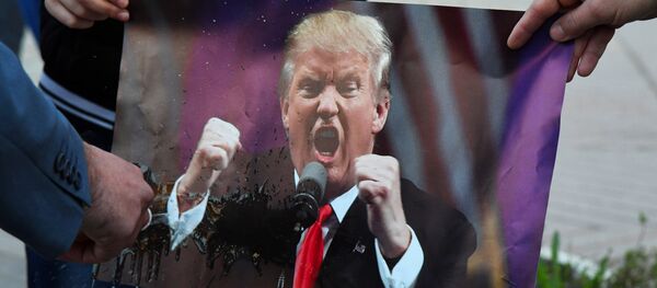 Участники акции против ракетных ударов по Сирии в Симферополе поджигают портрет президента США Дональда Трампа. - Sputnik Afrique