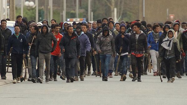 Migrants carrying sticks march in the streets of Calais, northern France, Thursday, Feb. 1, 2018. French authorities say four migrants have been shot in the northern port city of Calais in a confrontation that police tried to stop. - Sputnik Afrique