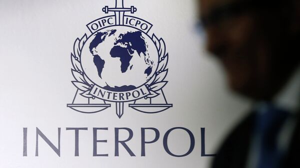 A man passes an Interpol logo during the handing over ceremony of the new premises for Interpol's Global Complex for Innovation, a research and development facility, in Singapore September 30, 2014 - Sputnik Afrique