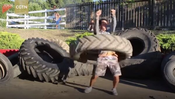 Man hola hoops with a 120 pound tractor tire - Sputnik Afrique