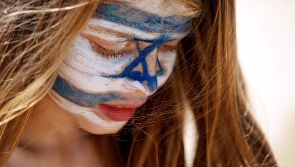 A girl with Israel's national flag painted on her face plays on the beach as part of the celebrations for Israel's Independence Day marking the 70th anniversary of the creation of the state, in Tel Aviv, Israel April 19, 2018. - Sputnik Afrique
