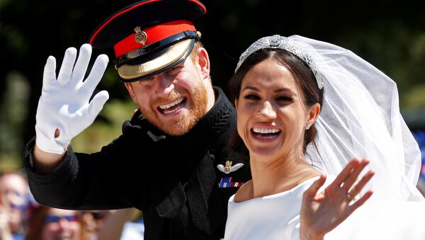 Britain’s Prince Harry and his wife Meghan wave as they ride a horse-drawn carriage after their wedding ceremony at St George’s Chapel in Windsor Castle in Windsor, Britain, May 19, 2018 - Sputnik Afrique
