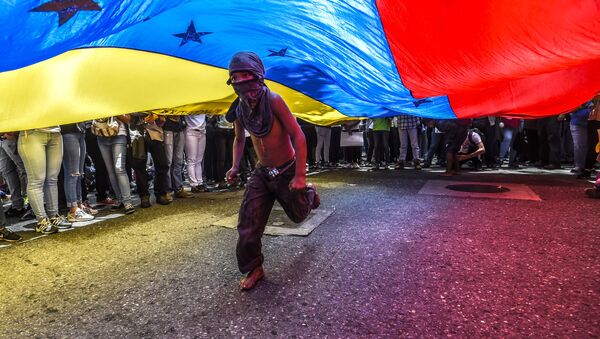 Мальчик бежит под венесуэльским флагом во время протеста журналистов и работников средств массовой информации против нападений на журналистов в Каракасе - Sputnik Afrique