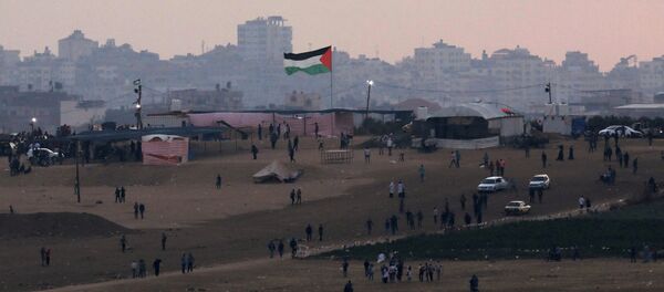 Palestinian protestors are seen next to the border fence between Israel, on the Gaza side of the border May 15, 2018 - Sputnik Afrique