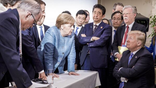German Chancellor Angela Merkel, center, details policy to US President Donald Trump, seated at right, during the G7 Leaders Summit in La Malbaie, Quebec, Canada, on Saturday, June 9, 2018 - Sputnik Afrique