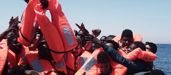 Migrants in an overcrowded plastic raft reach out for life jackets during a search and rescue operation by rescue ship Aquarius, operated by SOS Mediterranean and Doctors without Borders, in central Mediterranean Sea May 18, 2017 Migrants in an overcrowded plastic raft reach out for life jackets during a search and rescue operation by rescue ship Aquarius, operated by SOS Mediterranean and Doctors without Borders, in central Mediterranean Sea May 18, 2017 - Sputnik Afrique