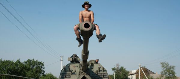 Ukrainian soldier sits atop of a self-propelled gun as an army column of military vehicles prepares to roll to a frontline near Illovaisk, Donetsk region, eastern Ukraine - Sputnik Afrique