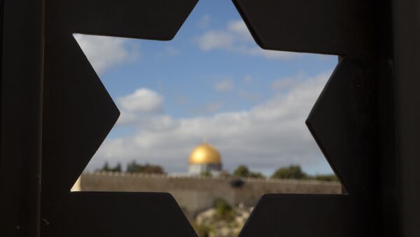 The Dome of the Rock Mosque in the Al-Aqsa Mosque compound in Jerusalem's Old City is seen through a door with the shape of star of David. - Sputnik Afrique