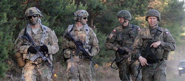 Paratroopers from the U.S. 82nd Airborne Division and the Polish 6th Airborne Division walk together after conducting a a multi-national jump on to a designated drop zone near Torun, Poland, Tuesday, June 7, 2016. The exercise, Swift Response-16, sets the stage in Poland for the multi-national land force training event Anakonda-16. - Sputnik Afrique