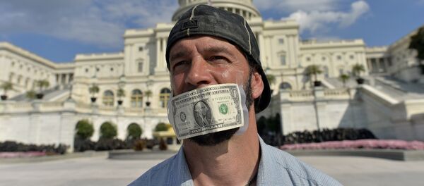 A protester covers his mouth with a dollar bill as he joins other in front of the US Capitol in Washington, DC, on October 1, 2013 urging congress to pass the budget bill. - Sputnik Afrique