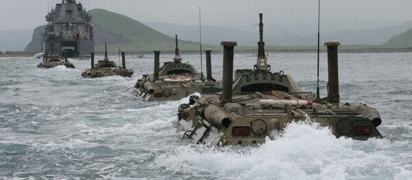 Колонна бронетранспортеров идет к большому десантному кораблю с целью погрузки на него на учениях морской пехоты Тихоокеанского флота по отработке элементов высадки десанта на необорудованный берег. - Sputnik Afrique