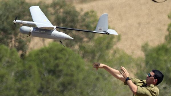 An Israel soldier launches an Israeli army's Skylark I unmanned drone aircraft, which is used for monitoring purposes, at an army deployment area near Israel's border with the besieged Palestinian territory, on August 4, 2014. - Sputnik Afrique