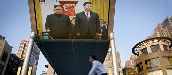 People bicycle past a giant TV screen broadcasting the meeting of North Korean leader Kim Jong Un and Chinese President Xi Jinping during a welcome ceremony at the Great Hall of the People in Beijing, Tuesday, June 19, 2018 People bicycle past a giant TV screen broadcasting the meeting of North Korean leader Kim Jong Un and Chinese President Xi Jinping during a welcome ceremony at the Great Hall of the People in Beijing, Tuesday, June 19, 2018 - Sputnik Afrique