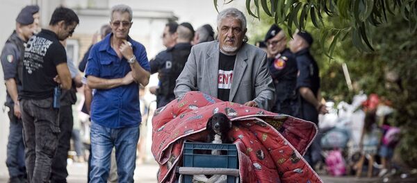 A man carries his belongings and his dog as he leaves a Gypsy camp to be evacuated and demolished in Rome, Thursday, Sept. 9, 2010. A man carries his belongings and his dog as he leaves a Gypsy camp to be evacuated and demolished in Rome, Thursday, Sept. 9, 2010. - Sputnik Afrique